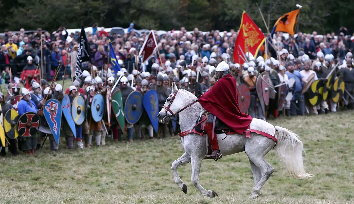 Seorang warga menaiki kuda saat ikut mereka ulang Pertempuran Hasting di Battle, Inggris, (15/10). Pertempuran Hasting ini juga disebut sebagai peperangan yang telah mengubah garis besar Inggris. (REUTERS/Neil Balai)