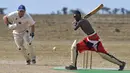 Seorang pria dari suku Maasai berusaha memukul bola saat pertandingan amal kriket di kaki Gunung Kenya (18/6). Pertandingan amal ini digelar untuk meningkatkan kesadaran akan nasib badak putih yang hampir punah. (AFP Phoo/Tony Karumba)