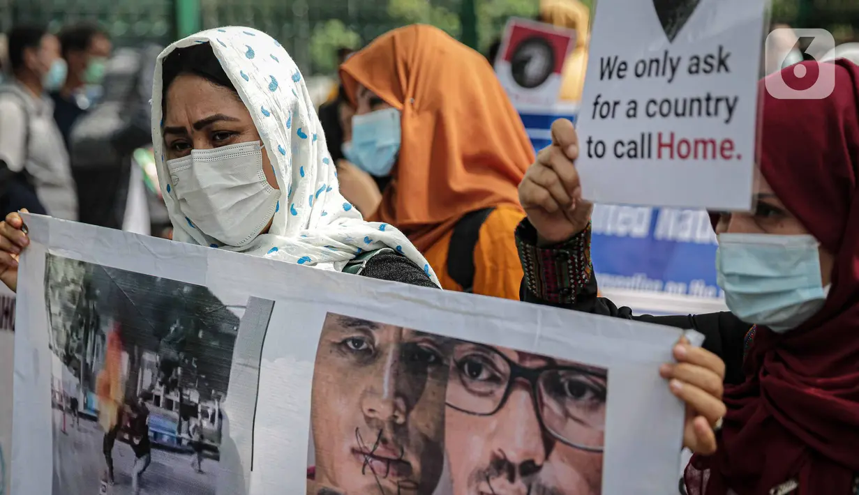 Sejumlah pengungsi Afghanistan membawa poster saat berunjuk rasa di kawasan Monas, Jakarta, Rabu (19/1/2022). Mereka menuntut kejelasan untuk berangkat ke negara ketiga setelah lama tinggal di pengungsian. (Liputan6.com/Faizal Fanani)