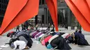 Sejumlah perempuan Muslim menunaikan salat disela-sela aksi protes terhadap Presiden AS Donald Trump terkait kebijakan pelarangan sejumlah negara muslim ke AS, di Chicago, Illinois, AS, Minggu (19/2). (AFP PHOTO / Joshua LOTT)
