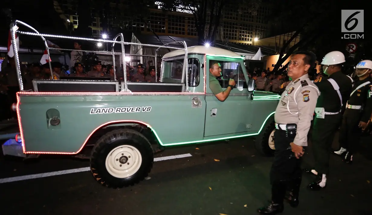 Petugas mengatur parkir mobil Land Rover klasik bak terbuka tumpangan Jokowi-Ma`ruf di gedung KPU Pusat, Jakarta, Jumat (21/9). Jokowi-Ma`ruf ke KPU untuk mengambil nomor urut Pilpres pasangan Capres dan Wapres 2019- 2024. (Liputan6.com/Fery Pradolo)