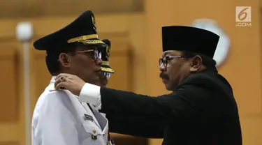 Gubernur Jawa Timur Soekarwo (kanan) melantik Bupati Tulungagung terpilih hasil Pilkada 2018, Syahri Mulyo di Jakarta, Selasa (25/9). Syahri saat ini sudah berstatus tahanan KPK. (Merdeka.com/Imam Buhori)