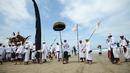 Umat Hindu menyusuri pantai saat menggelar ritual Melasti di Pantai Petitenget, Denpasar, Bali, Senin (4/3). Dalam sejarah, Melasti disimbolkan dengan gunungan sesaji yang dihanyutkan ke laut. (SONNY TUMBELAKA/AFP)