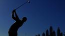 Siluet pegolf Inggris, Danny Willett, saat memukul bola dalam turnamen golf Dubai Desert Classic 2016 di Emirates Golf Club, Dubai, (7/2/2016). (AFP/Karim Sahib)