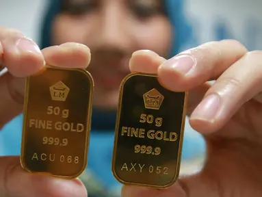 Seorang teller menunjukan emas batangan di Jakarta, Selasa (15/11). Harga emas batangan atau Logam Mulia milik PT Aneka Tambang Tbk (Antam) hari ini dibuka turun Rp 2.000/gram. (Liputan6.com/Angga Yuniar)