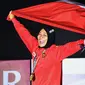 Peraih medali emas Indonesia Susanti Rahayu Aries membawa bendera merah putih pada upacara penyerahan medali olahraga panjat tebing wanita Asian Games 2018 di Palembang (23/8). (AFP PHOTO / Adek Berry)