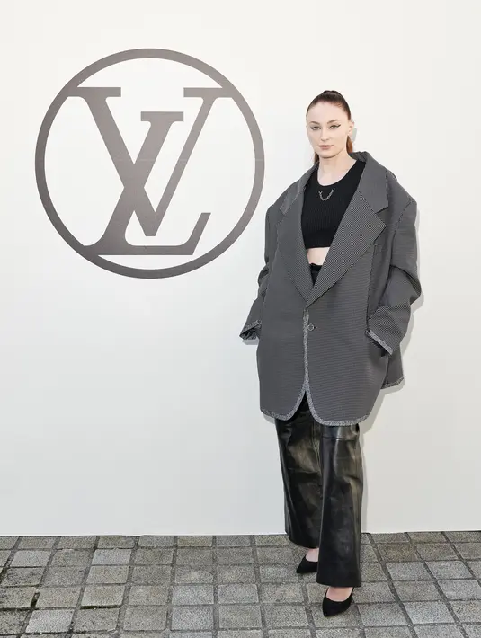 Hadir bersama sang suami, Sophie Turner tampil lebih tone down dengan croptop dan leather pants. Dipadukan dengan oversized blazer dan heels hitam. (Louis Vuitton)