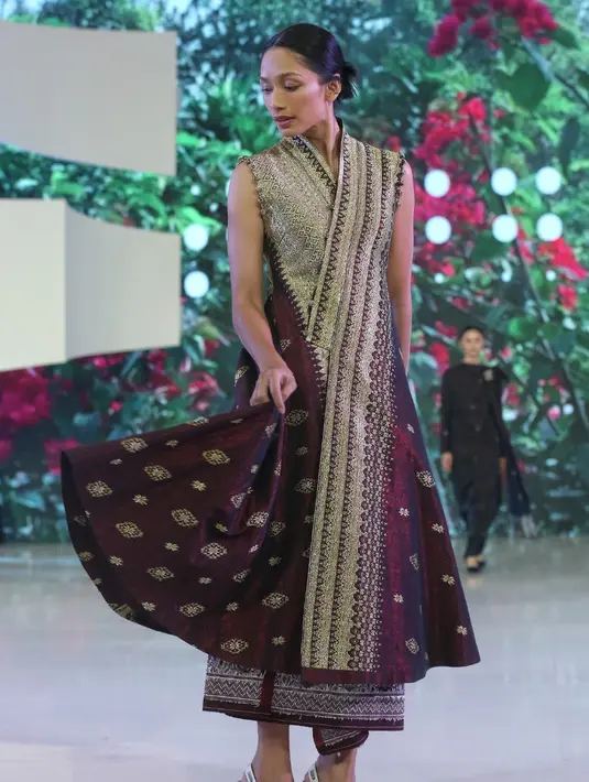 Faradina Mufti tampil mengenakan wide knife coat tenun pandai Sikek dengan luar berlipit tajam dengan siluet bervolume. Bagian bawah tumpang tindih asimetris dengan kancing tersembunyi. [Adrian/Fimela]