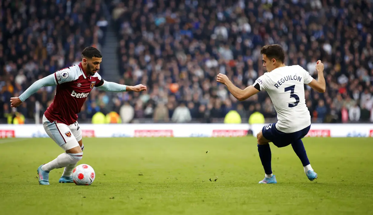 Pemain West Ham United Said Benrahma (kiri) berebut bola dengan pemain Tottenham Hotspur Sergio Reguilon pada pertandingan sepak bola Liga Inggris di Tottenham Hotspur Stadium, London, Inggris, Minggu (20/3/2022). Tottenham Hotspur menang 3-1. (AP Photo/David Cliff)