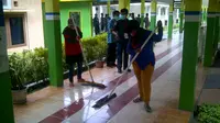 Dua petugas kebersihan RSUD Imanuddin sedang membersihkan lantai dari ceceran cairan jenazah korban AirAsia QZ8501 (Liputan6.com/Oscar Ferri)