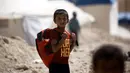 Senyum anak pengungsi saat berangkat ke sekolah di sebuah kamp di Ain Issa, Suriah (22/8). Meski belajar di dalam tenda pengungsian, anak-anak tetap antusias mengikuti hari pertama tahun ajaran baru sekolah. (AFP Photo/Delil souleiman)