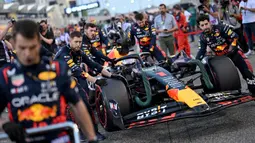 Pebalap Red Bull, Max Verstappen bersama timnya sedang bersiap untuk melakukan start saat Formula 1 GP Bahrain 2023 yang berlangsung di Sirkuit Internasional Bahrin, Sakhir, Minggu (05/03/2023) WIB. (AFP/Andrej Isakovic)