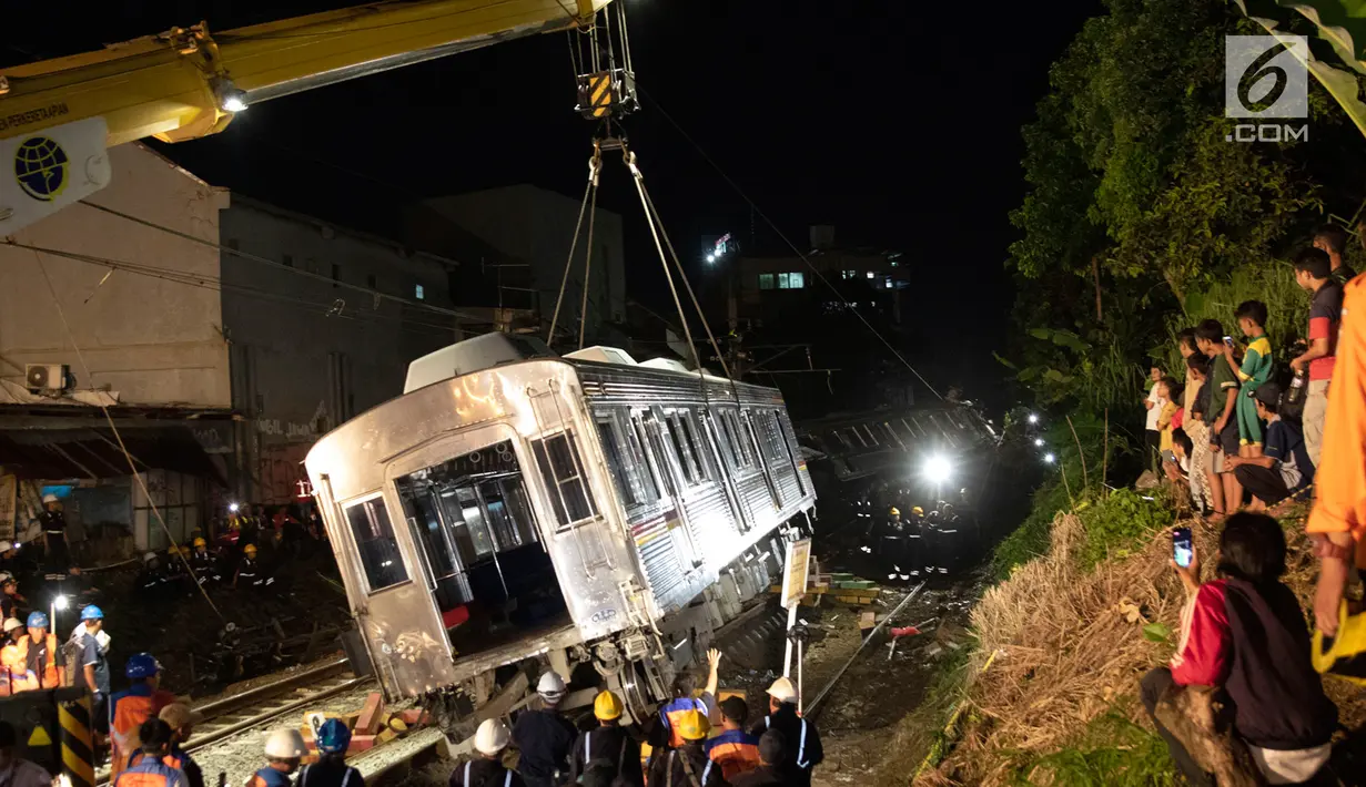 Petugas dibantu alat berat mengevakuasi gerbong KRL Commuter Line jurusan Jatinegara - Bogor di kawasan Kebon Pedes, Bogor, Jabar Minggu (10/3). Proses evakuasi menggunakan crane yang didatangkan dari Bandung. (Liputan6.com/Immanuel Antonius) 