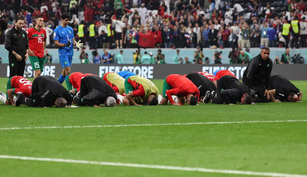 Para pemain Maroko tetap bersujud syukur usai pertandingan melawan Prancis pada semifinal Piala Dunia 2022 di Stadion Al-Bayt di Al Khor, Doha, Kamis (15/12/2022). Maroko kalah dari Prancis 2-0 dan gagal melaju ke final Piala Dunia 2022. (AFP/Karim Jaafar)