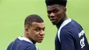 Pemain Timnas Prancis, Kylian Mbappe (kiri) dan Aurelien Tchouameni saat berlatih jelang Euro 2024 di Home Deluxe Arena Stadium, Paderborn, Jerman, Rabu (12/06/2024) waktu setempat. (AFP/Franck Fife)