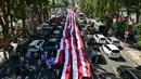 Diketahui, Kota Surabaya di Jawa Timur yang menjadi salah satu kota besar di Indonesia turut serta dalam memeriahkan HUT ke-80 Kemerdekaan dengan berbagai kegiatan, termasuk upacara dan arak-arakan bendera Merah Putih. (Juni KRISWANTO/AFP)