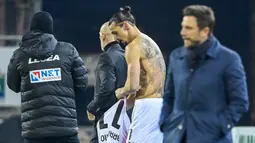 Striker AC Milan, Zlatan Ibrahimovic, menukar jersey saat melawan Cagliari pada laga Liga Italia di Sardegna Arena, Senin (19/1/2021). AC Milan menang dengan skor 2-0. (AFP/Alberto Pizzoli)