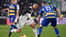 Striker Juventus, Cristiano Ronaldo, berusaha melewati gelandang Parma, Jasmin Kurtic, pada laga Serie A di Stadion Juventus, Turin, Minggu (19/1). Juventus menang 2-1 atas Parma. (AFP/Marco Bertorello)