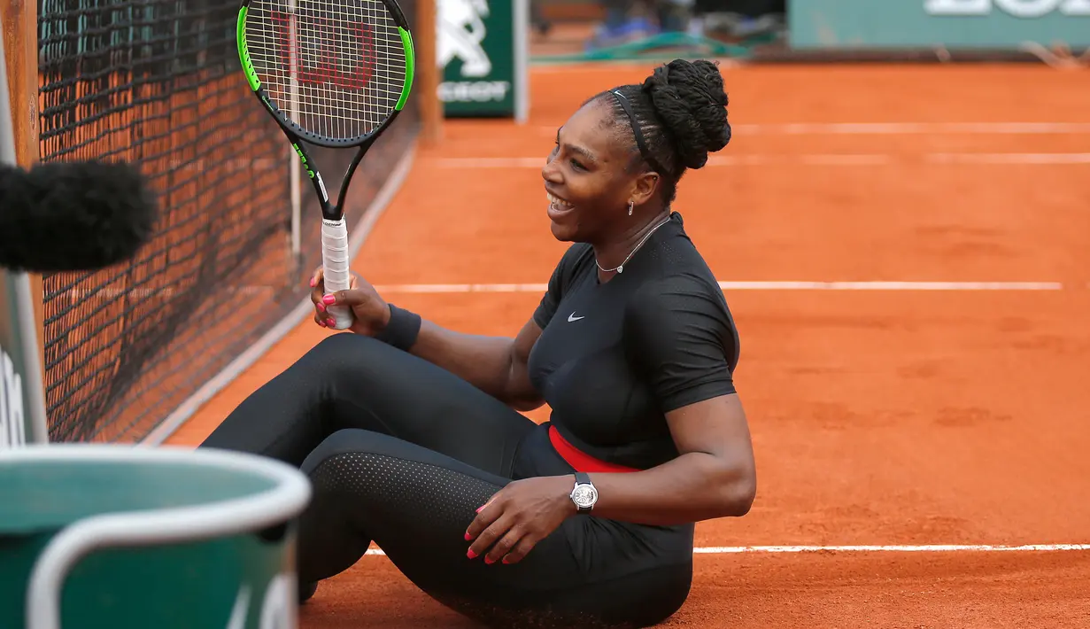 Serena Williams tertawa setelah ia tergelincir di lapangan saat melawan Krystina Pliskova dalam turnamen tenis Perancis Terbuka di stadion Roland Garros di Paris, Prancis (29/5). (AP / Michel Euler)