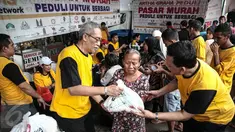 Senior Artha Graha Peduli Heka Hertanto (kiri) memberikan sembako pada Pasar Murah Ramadan 2016 di kawasan Pasar Benhil, Jakarta, Minggu (5/6/2016). Pasar Murah Ramadan 2016 ini diadakan oleh Artha Graha Peduli. (Liputan6.com/Faizal Fanani)