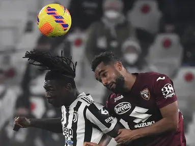 Penyerang Juventus Moise Kean (kiri) berebut bola dengan bek Torino Koffi Djidji dalam pekan 26 Serie A Liga Italia di Allianz Stadium, Sabtu (19/2/2022) dinihari WIB. Juventus ditahan imbang Torino 1-1. (Filippo MONTEFORTE / AFP)