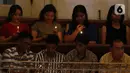 Jemaat menyalakan lilin saat mengikuti kebaktian malam Natal 2019 di Gereja Protestan Indonesia Bagian Barat (GPIB) Imanuel,  Jakarta, Selasa (24/12/2019). (Liputan6.com/Herman Zakharia)