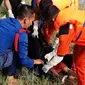 Petugas mengevakuasi jasad nenek yang ditemukan mengapung di Sungai Siak. (Liputan6.com/M Syukur)