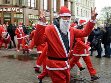 Peserta mengenakan kostum Sinterklas ikut serta dalam kegiatan amal Santa's Fun Run di Riga, Latvia, Minggu (8/12/2019). Ini merupakan acara amal yang pesertanya bersenang-senang dengan berlari atau berjalan kaki untuk mengumpulkan dana bagi anak-anak di rumah sakit Latvia. (Gints Ivuskans/AFP)