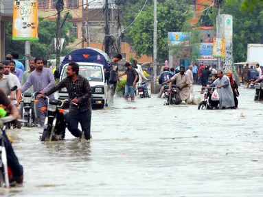 Para pengendara sepeda motor menuntun kendaraan mereka melewati banjir usai hujan monsun di Kota Karachi, Pakistan, 25 Agustus 2020. Menurut Departemen Meteorologi Pakistan, hujan monsun yang lebat pada Agustus ini memecahkan rekor sebagai curah hujan tertinggi dalam 36 tahun terakhir. (Xinhua/Str)