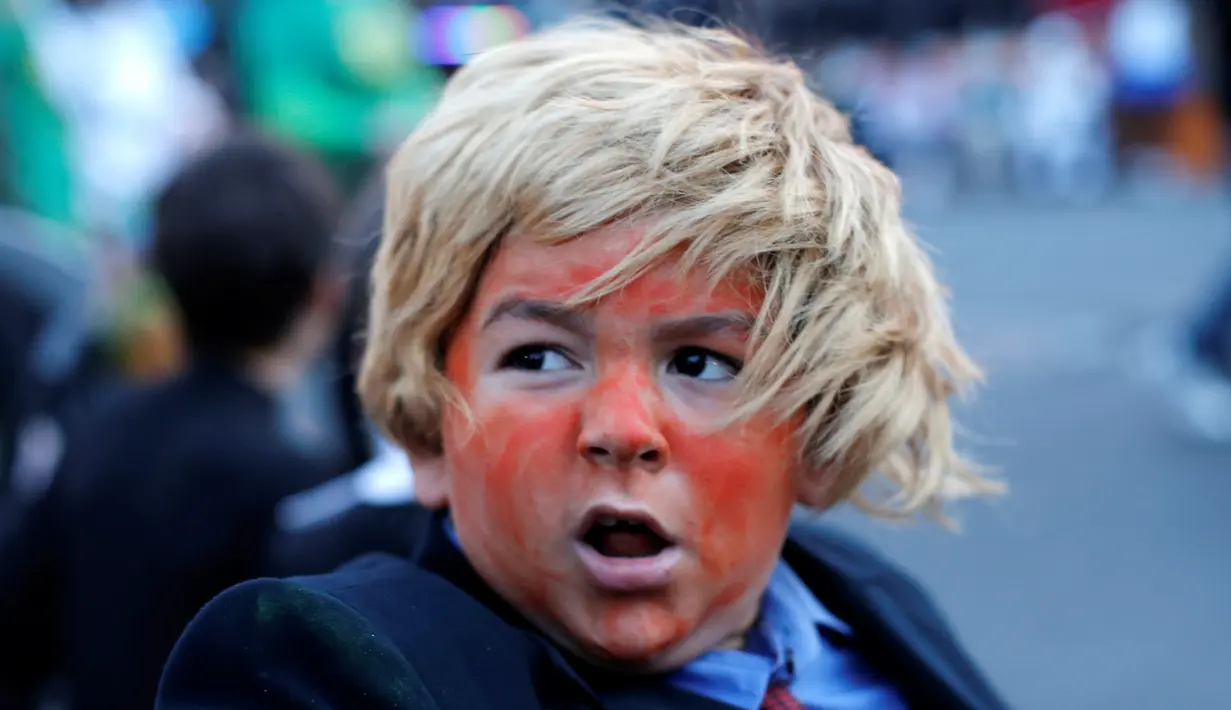 Seorang anak laki-laki berpakaian seperti calon presiden dari Partai Republik, Donald Trump saat acara tahunan Parade Nyack Halloween di Desa Nyack, New York, AS (29/10). (Reuters/Mike Segar)