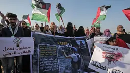 Sejumlah warga Palestina membawa poster saat menggelar aksi protes terkait pembunuhan wartawan Yasser Murtaja di dekat perbatasan Israel-Gaza, Palestina (8/4). (AFP Photo/Said Khatib)
