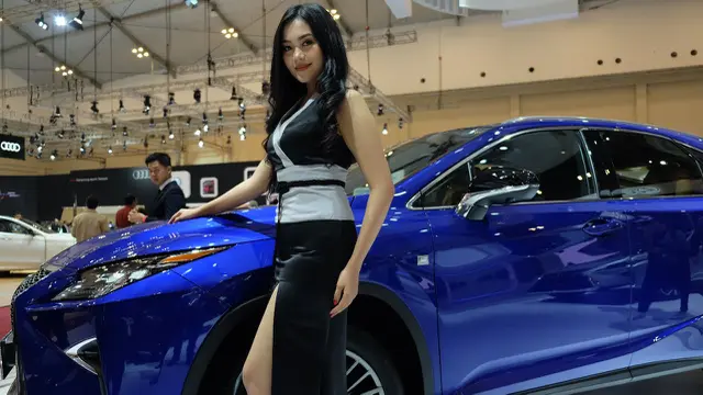 Usher berpose di samping sedan Lexus