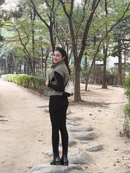 Dengan wajah make up no makeup, Nabila mengenakan padding vest hijau Army dipadukan inner lengan panjang dan celana hitam. Sambil membawa tas Chanel putih. [@nsyakieb85]