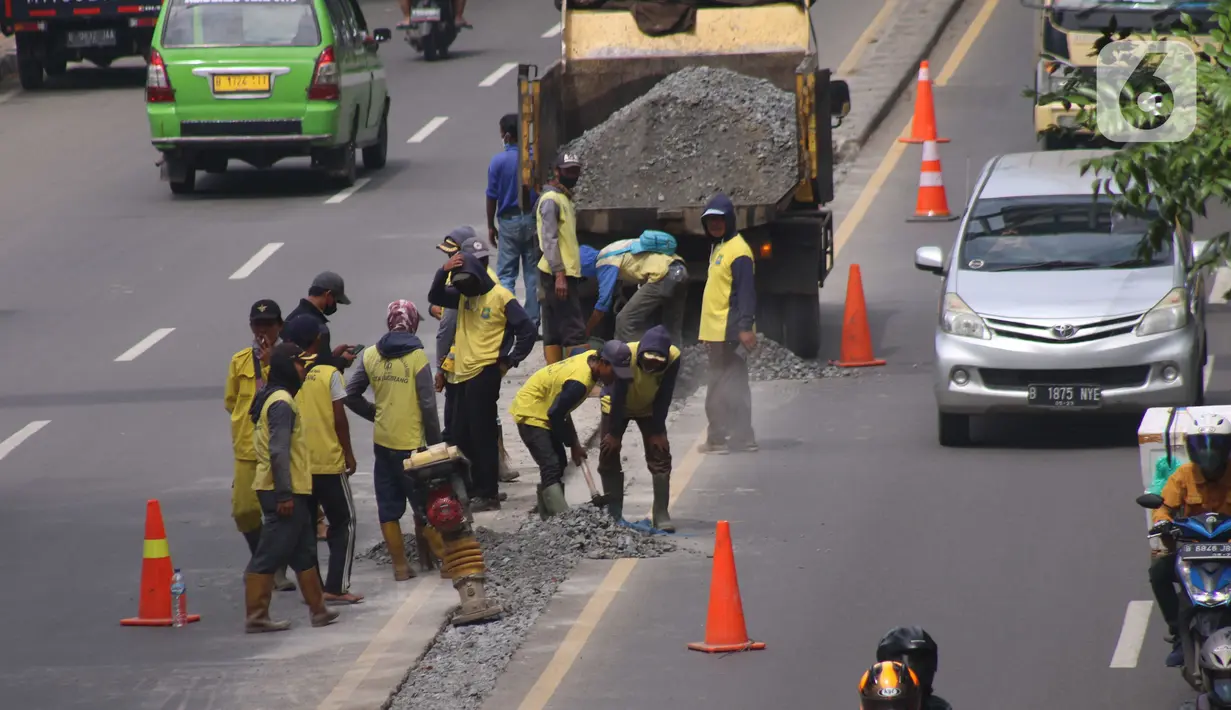 Pekerja melakukan penataan di ruas jalan nasional di Jalan Daan Mogot, Kota Tangerang, Banten, Selasa (15/2/2022). Pemkot Tangerang berencana melakukan sistem satu arah di Jalan Daan Mogot untuk mengatasi kemacetan di akses masuk tol Cengkareng-Batu Ceper-Kunciran. (Liputan6.com/Angga Yuniar)