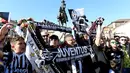 Suporter Juventus membentangkan shal merayakan kemenangan usai merebut gelar Serie A Italia di pusat kota Turin, Italia (25/4). Juventus berhak meraih gelar Scudetto mereka yang ke-34. (REUTERS/Giorgio Perottino)