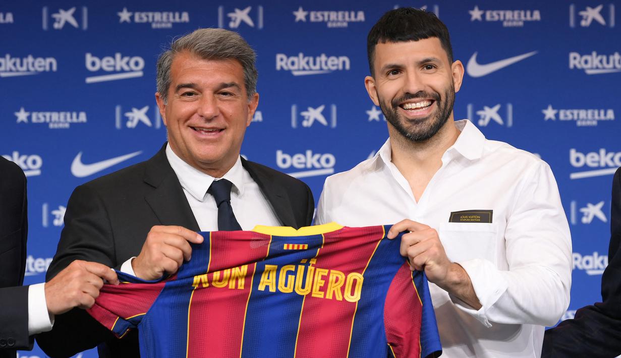 Sergio Aguero (kanan) berpose dengan presiden FC Barcelona Joan Laporta selama presentasi resminya sebagai pemain baru FC Barcelona di stadion Camp Nou, Barcelona (31/05/2021). Merka telah menandatangani kontrak hingga tahun 2023 dengan klausal pembelian 100 juta Euro. (Foto: AFP/Lluis Gene)