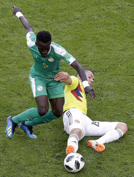 Aksi pemain Kolombia, Mateus Uribe (kanan) menghalau bola dari kaki pemain Senegal, Senegal, Idrissa Gana Gueye pada laga terakhir grup H di Samara Arena, Samara, Rusia, (28/6/2018). Kolombia menang 1-0. (AP/Gregorio Borgia)