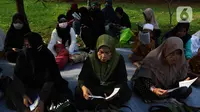 Umat Islam membaca Al-Quran sambil menunggu waktu berbuka puasa di halaman Masjid Raya Jakarta Islamic Center, Jakarta Utara, Senin (18/4/2022). Acara ngabuburit sambil khataman Al-Quran ini merupakan rangkaian acara menyambut 17 Ramadhan atau malam Nuzulul Quran. (Liputan6.com/Herman Zakharia)