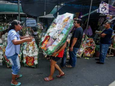 Penjual membawa parsel yang telah selesai dihias untuk dijual dikawasan Cikini, Jakarta, Sabtu (17/6). Satu pekan jelang Idul Fitri 1438 H penjualan parcel mulai mengalami peningkatan. (Liputan6.com/Faizal Fanani)