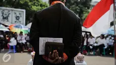 Seorang pendeta memimpin pelaksanakan ibadah peringati hari Paskah di depan Istana Negara, Jakarta, Minggu (27/3/2016). Mereka meminta pemerintah untuk memberikan solusi bagi permasalahan tempat ibadah mereka. (Liputan6.com/Faizal Fanani)