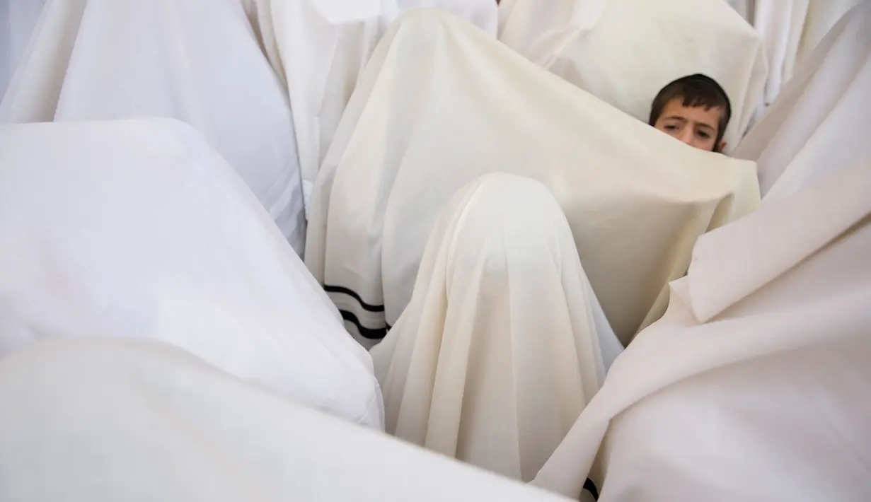 Eskpresi seorang anak yang mengikuti berdoa menjelang Paskah di depan Tembok Barat, Yerusalem (13/4). (AP Photo / Ariel Schalit) 