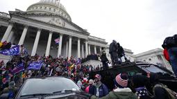 Ribuan massa pendukung Trump menyerbu ke dalam Gedung Kongres di Capitol Hill untuk menolak pengesahan hasil pemilihan presiden 2020 pada Rabu (6/1). Untuk membubarkan massa,, aparat menembakkan gas air mata hingga terlibat baku hantam. (AP Photo/Julio Cortez)