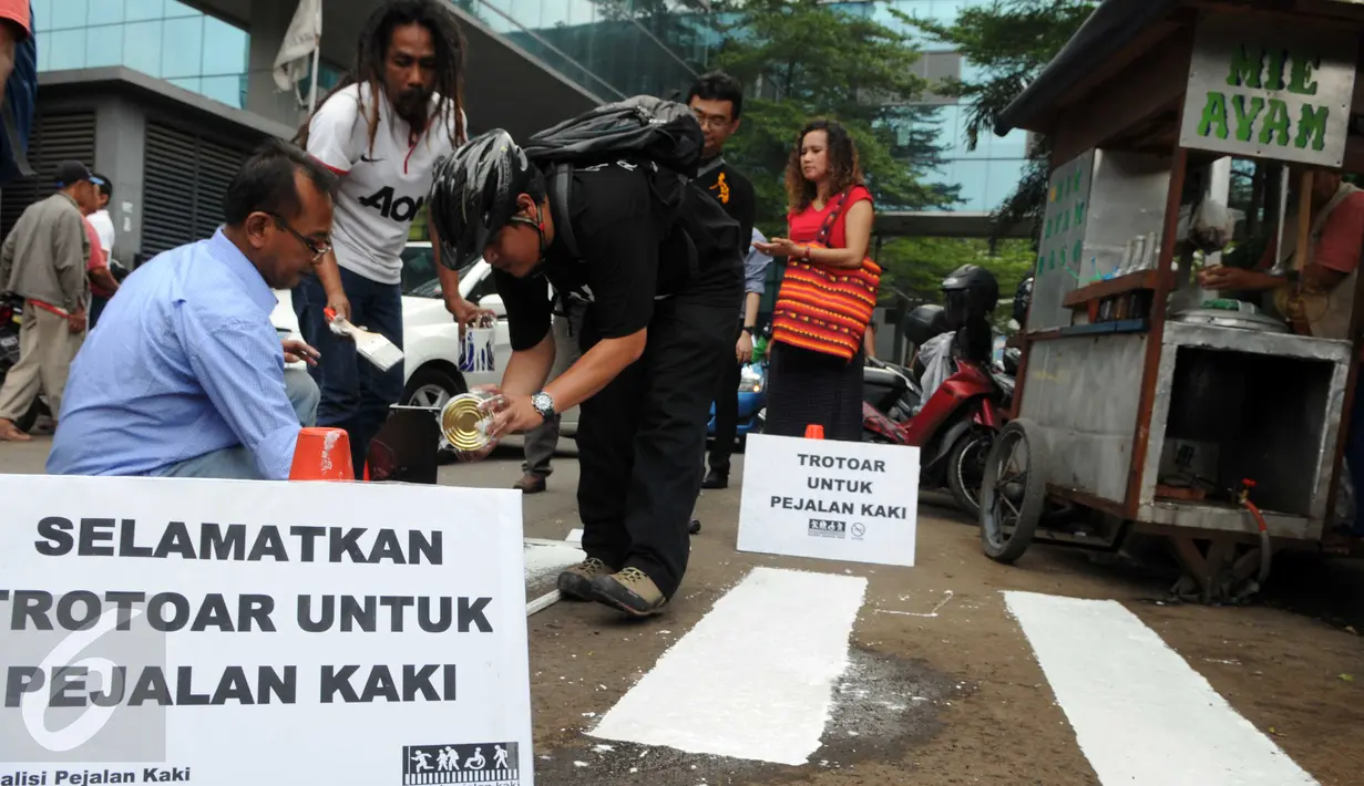 Para Aktivis Pejalan Kaki mengecat marka jalan  di kawasan Tosari, Jakarta, Jumat (11/12). Mereka mengajak masyarakat agar sadar untuk berlalu lintas jalan yang aman dan selamat. (Liputan6.com/Helmi Afandi)