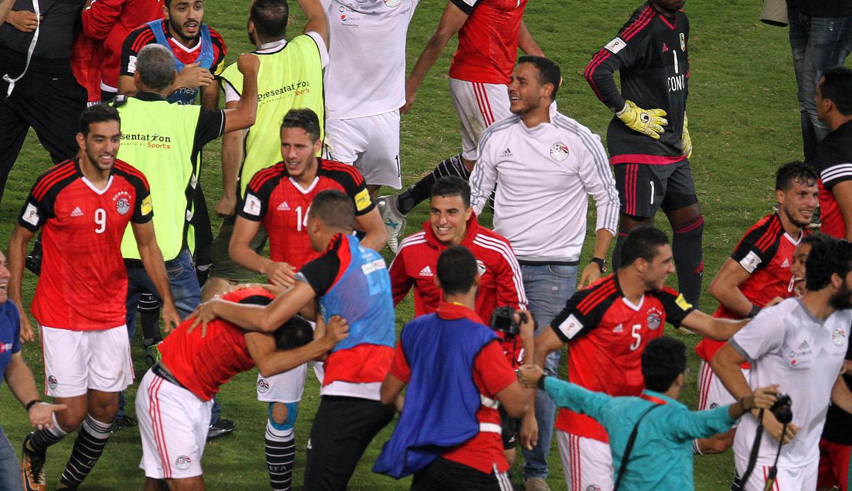 Para pemain Mesir merayakan keberhasilan negaranya lolos ke Piala Dunia 2018 di Stadion Borg El Arab, Alexandria, Senin (8/10/2017). Mesir lolos ke Piala Dunia setelah absen sejak gelaran tahun 1990. (AFP/Tarek Abdel Hamid)
