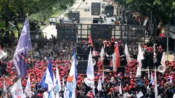 Ribuan massa buruh tertahan blokade apparat keamanan di Jalan Medan Merdeka Barat, Senin (5/1). Ribuan massa buruh turun ke jalan dalam perayaan Hari Buruh Internasional. (Liputan6.com/Helmi Fithriansyah)