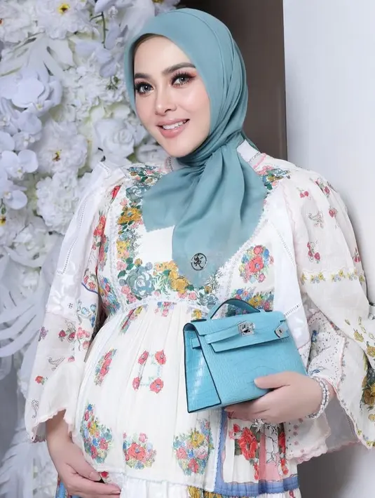 Dress tersebut dipadukan dengan kerudung warna hijau. Tak lupa ia membawa clutch warna hijau dari Hermes. [@princessyahrini]