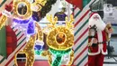 Seorang anak berfoto di dekat pernak pernik Natal di Living World, Tangerang Selatan, Senin (13/12/2021). Jelang perayan Natal sejumlah pusat perbelanjaan dihiasi ornamen Natal yang dijual. (Liputan6.com/Anga Yuniar)
