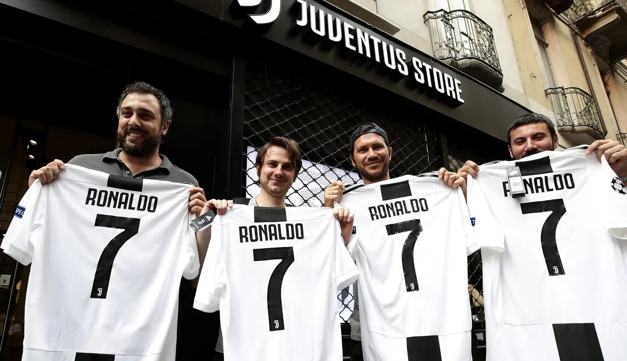 Suporter memperlihatkan jersey Juventus atas nama Cristiano Ronaldo di depan toko resmi klub di Turin, Selasa (10/7). Cristiano Ronaldo resmi pindah dari Real Madrid ke Juventus pada bursa transfer musim ini. (AFP PHOTO / Isabella Bonottovv)