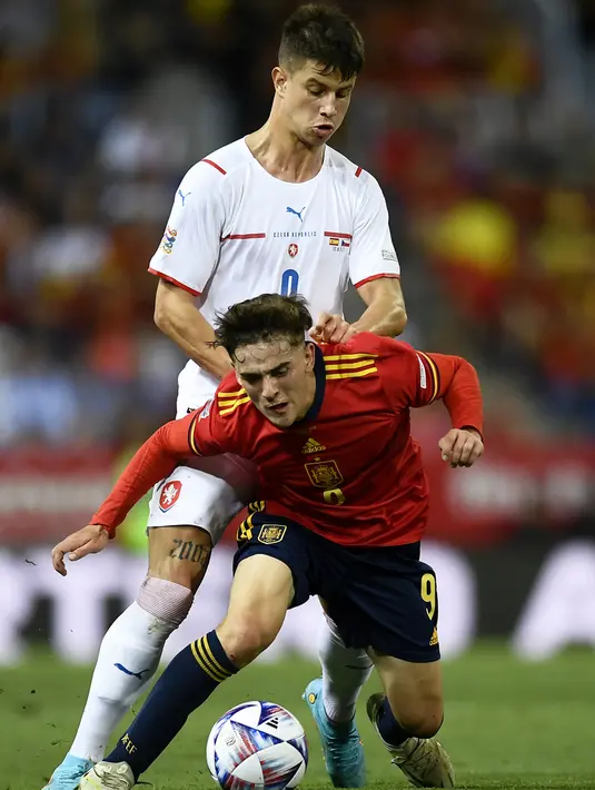 <p>Pemain Republik Ceko Adam Hlozek (belakang) berebut bola dengan pemain Spanyol Gavi pada pertandingan sepak bola UEFA Nations League di Stadion La Rosaleda, Malaga, Spanyol, 12 Juni 2022. Spanyol menang 2-0. (AP Photo/Jose Breton)</p>