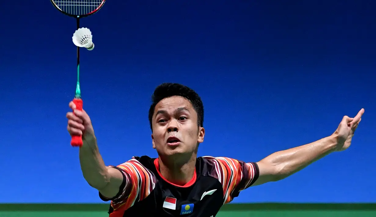 Tunggal putra Indonesia, Anthony Sinisuka Ginting melakukan servis ke arah lawannya tunggal putra Jepang, Kento Momota pada babak perempat final Jepang Terbuka 2019 di Tokyo, Jumat (26/7/2019). Anthony Ginting, tersingkir setelah kalah dengan skor 13-21, 22-20 dan 15-21. (TOSHIFUMI KITAMURA/AFP)